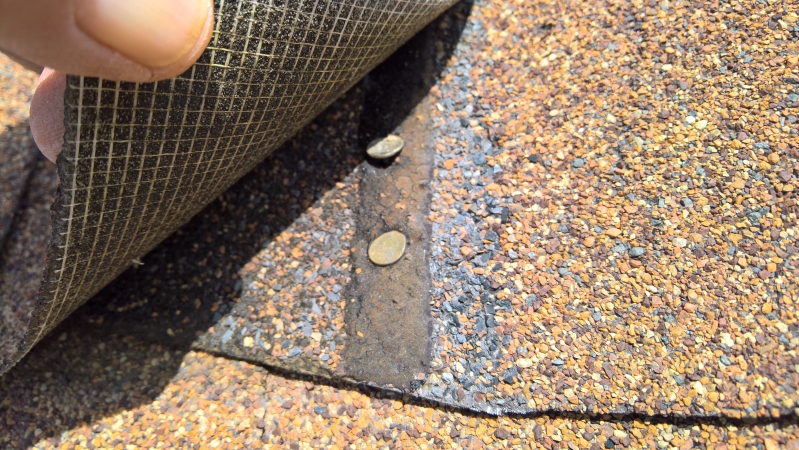 One ridge shingle nail crooked-both incorrectly placed into factory sealant